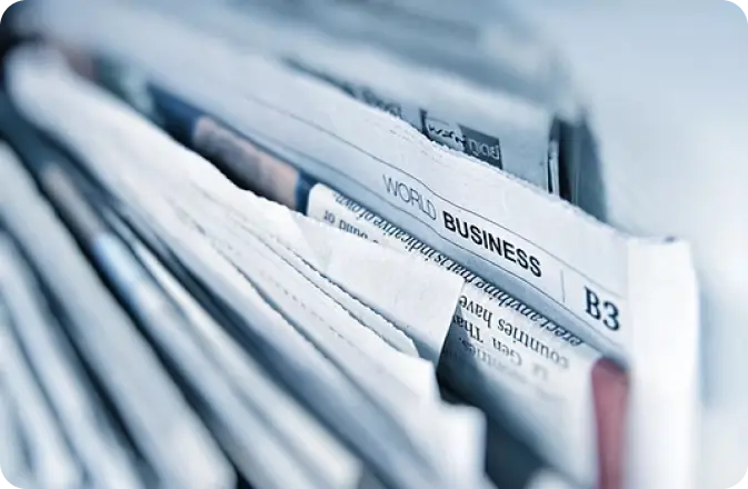 Close-up of stacked newspapers used as background image for Ymmunobio news and publication posts